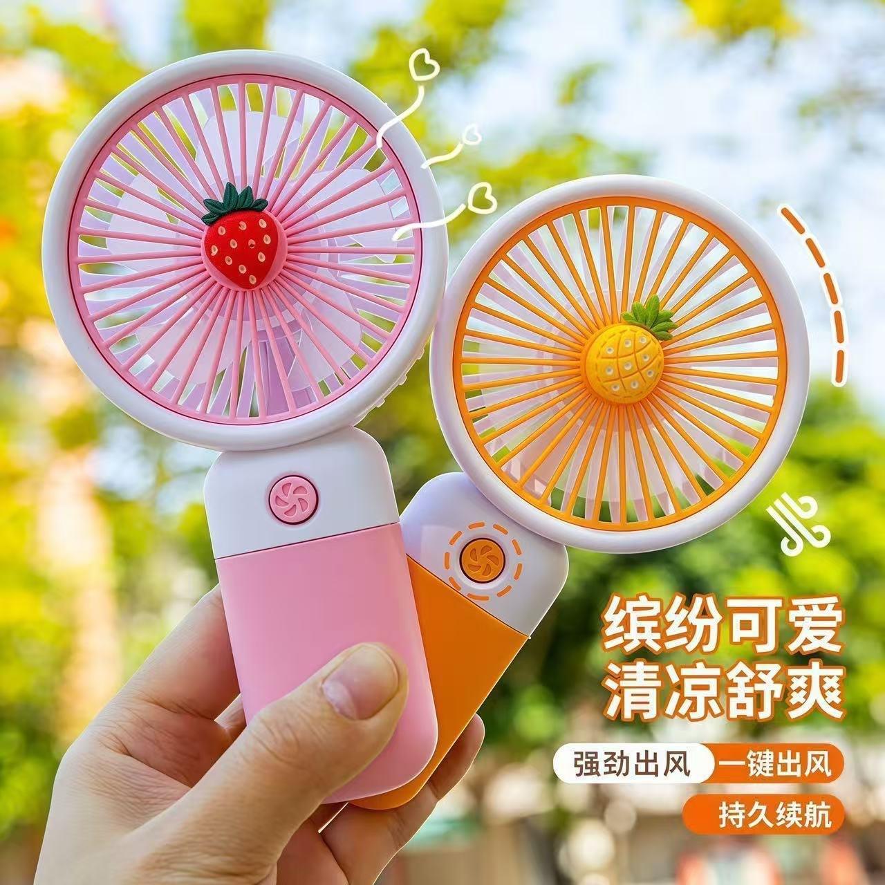 Mini handheld fan with cartoon fruit design, with base and phone stand, portable for office and student use, desktop fan wholesale